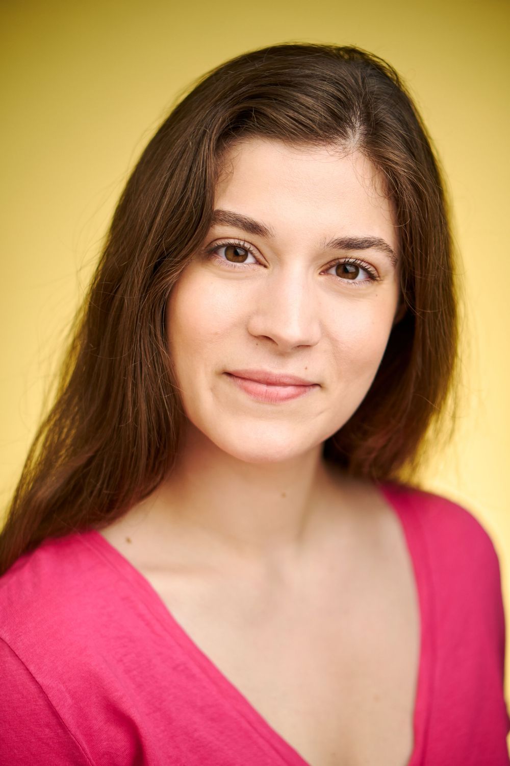 Portrait en studio en haut rose sur fond jaune chaud.