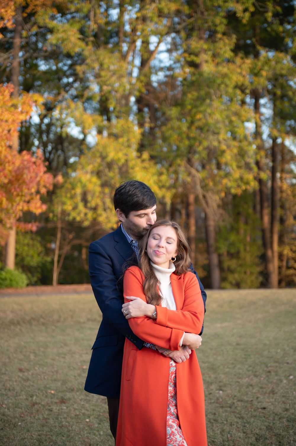 Fall engagement photos showing tender moments in a sun-dappled field.