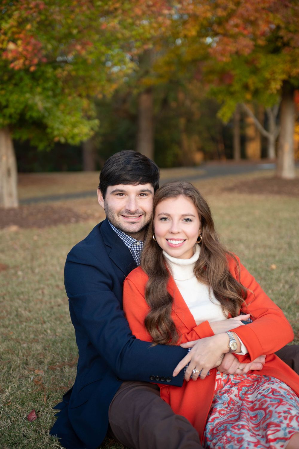 Couple sharing playful moments during autumn photoshoot with golden foliage.