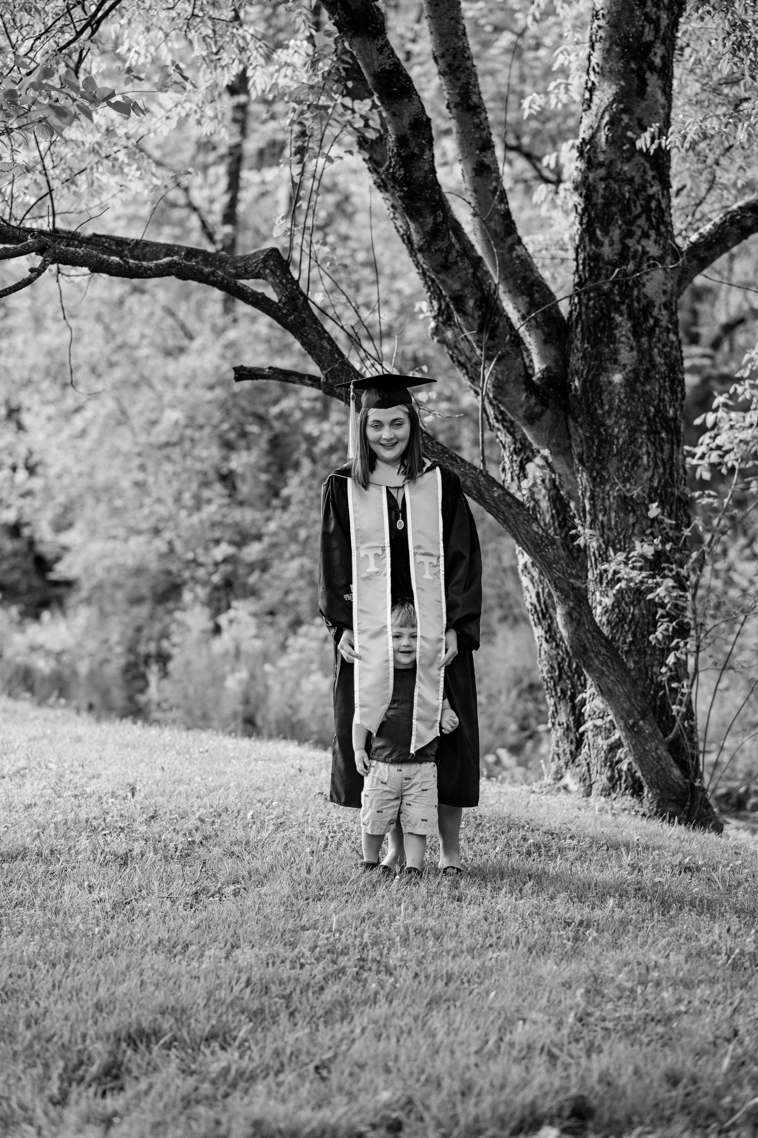 Black and white graduation photos captured in natural woodland setting.