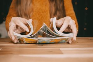 From neck down someone is shuffling tarot cards