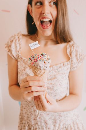 A woman holding an ice cream cone smiling