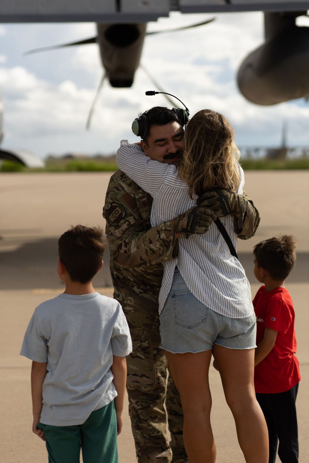 Family embracing during military homecoming at Cannon AFB.