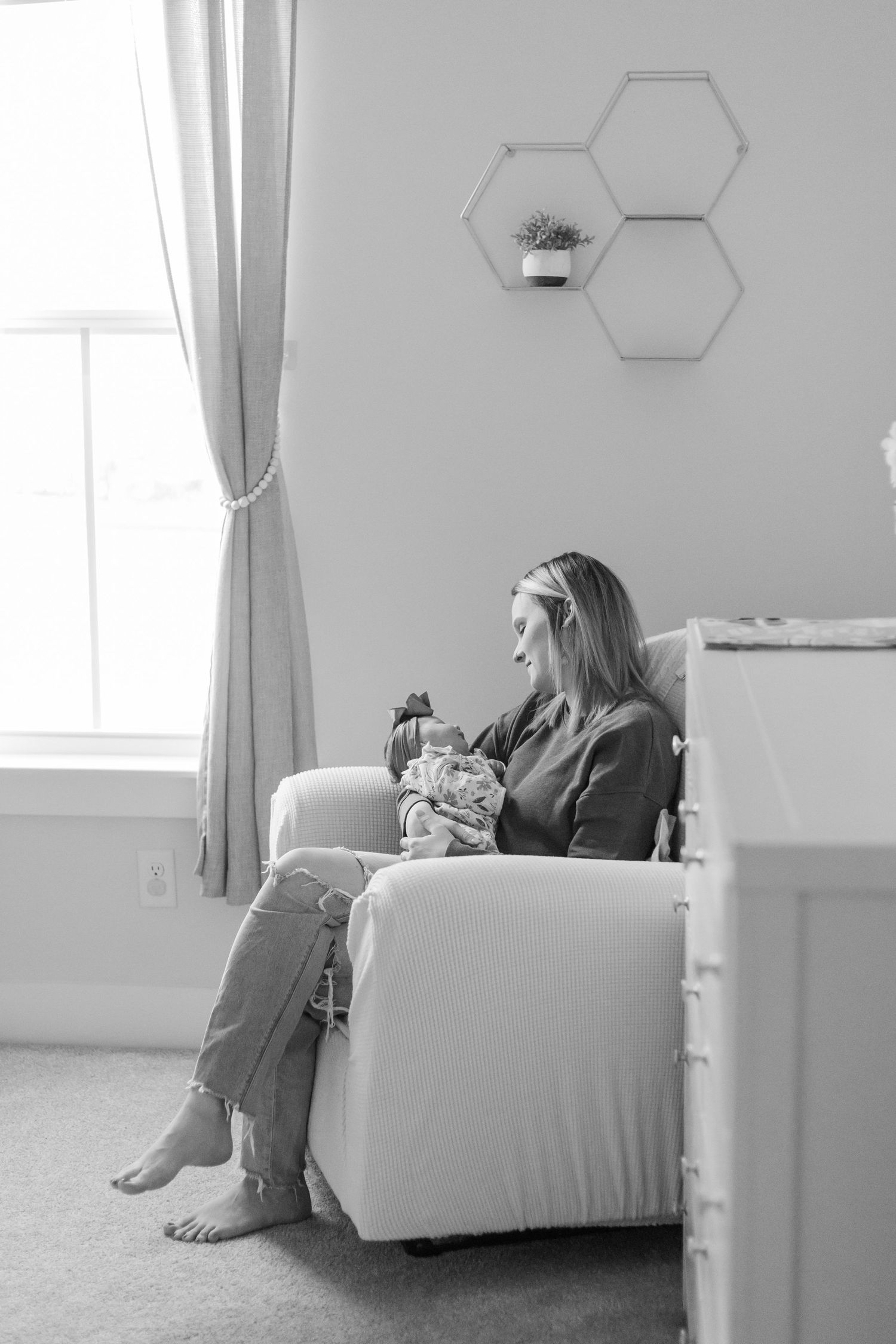 Close up view of small baby being held against window light.