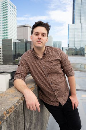 Urban rooftop portrait with modern city buildings and skyscrapers in background.