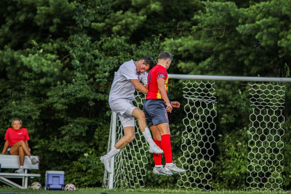 Soccer player fighting to head the ball