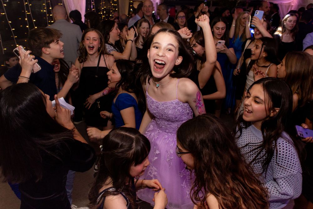 Girls dancing with their hands in the air - Bat Mitzvah Photography