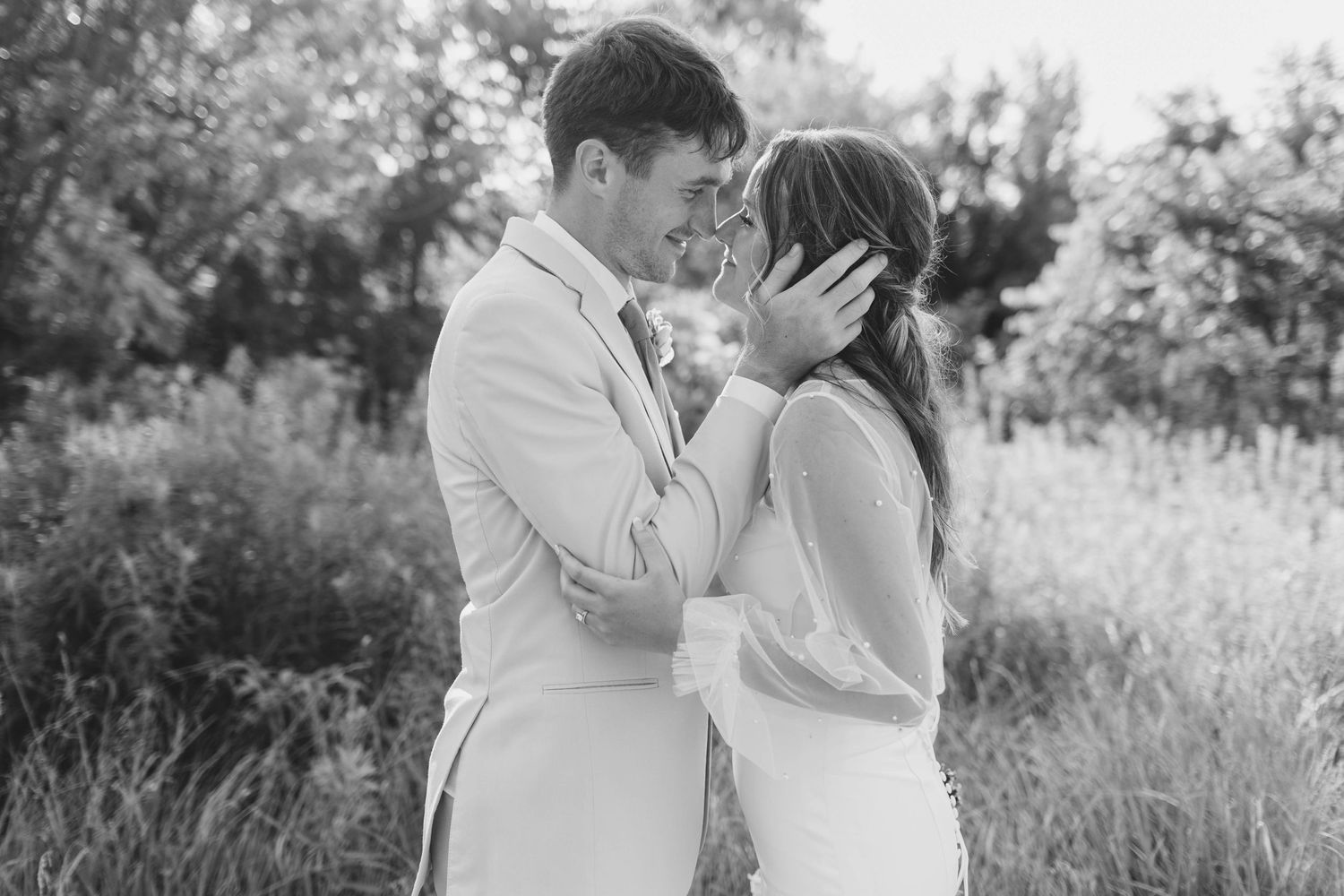 A romantic black and white portrait in a wildflower field with soft natural lighting.