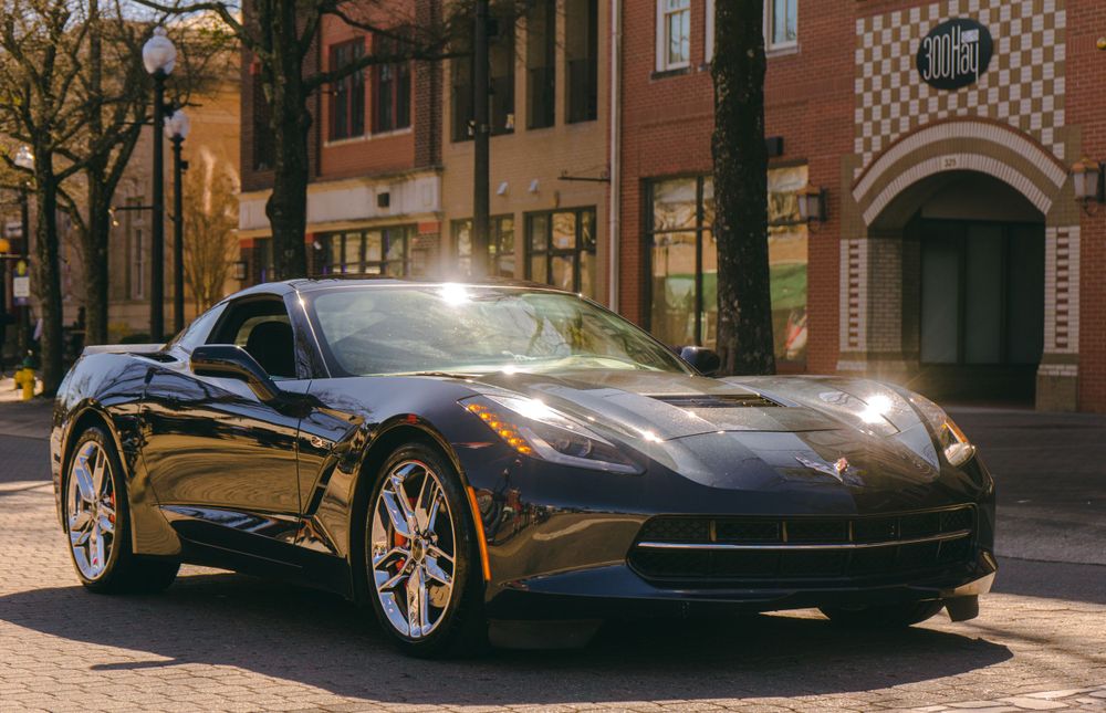 Black Chevrolet Corvette showcasing its sleek design on a city street.