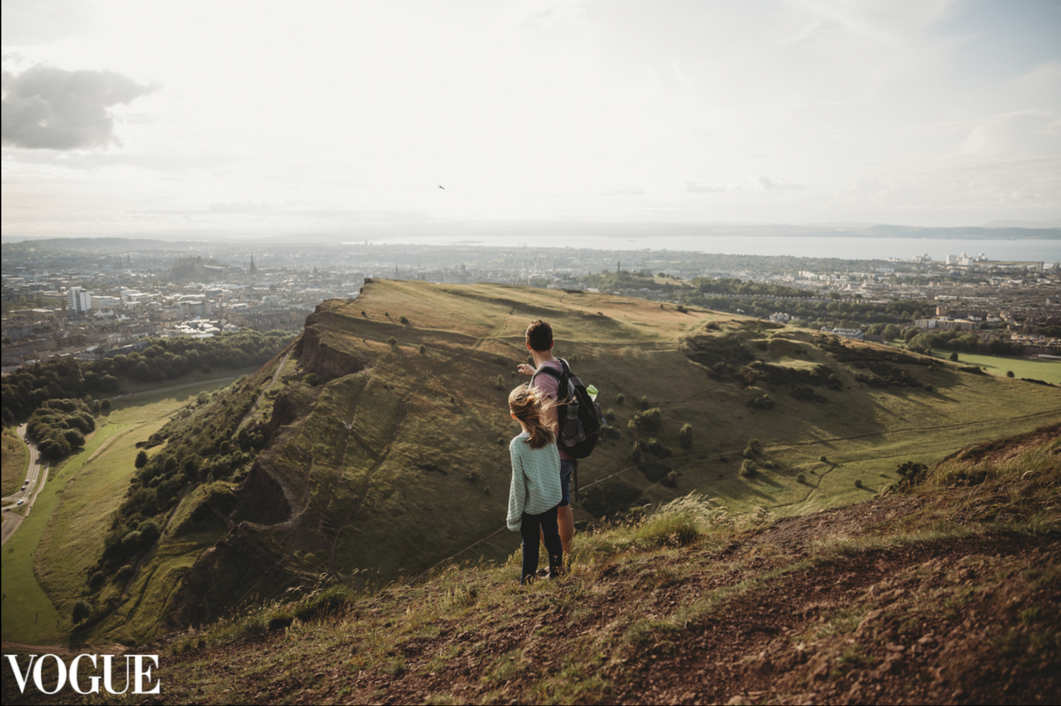 A scenic overlook from a hilltop showing a dramatic city vista below.