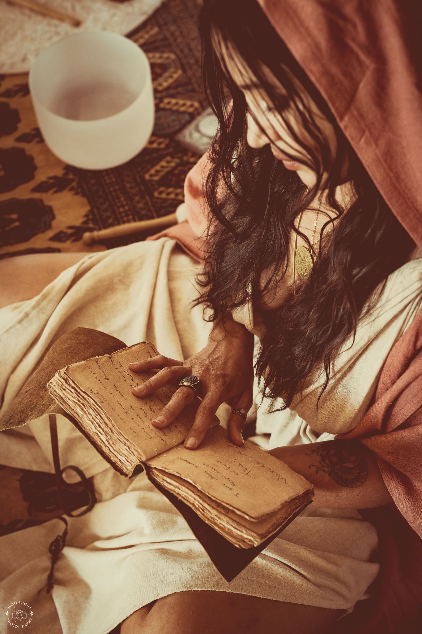 Person in sepia tones reading from a rustic old book with weathered pages. Branding photography Las Vegas