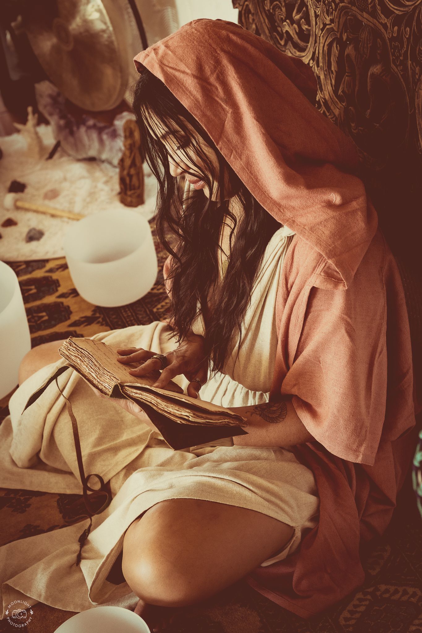 Vintage-style sepia photograph showing hands reading a a scared book in atmospheric lighting. Branding photography Las Vegas