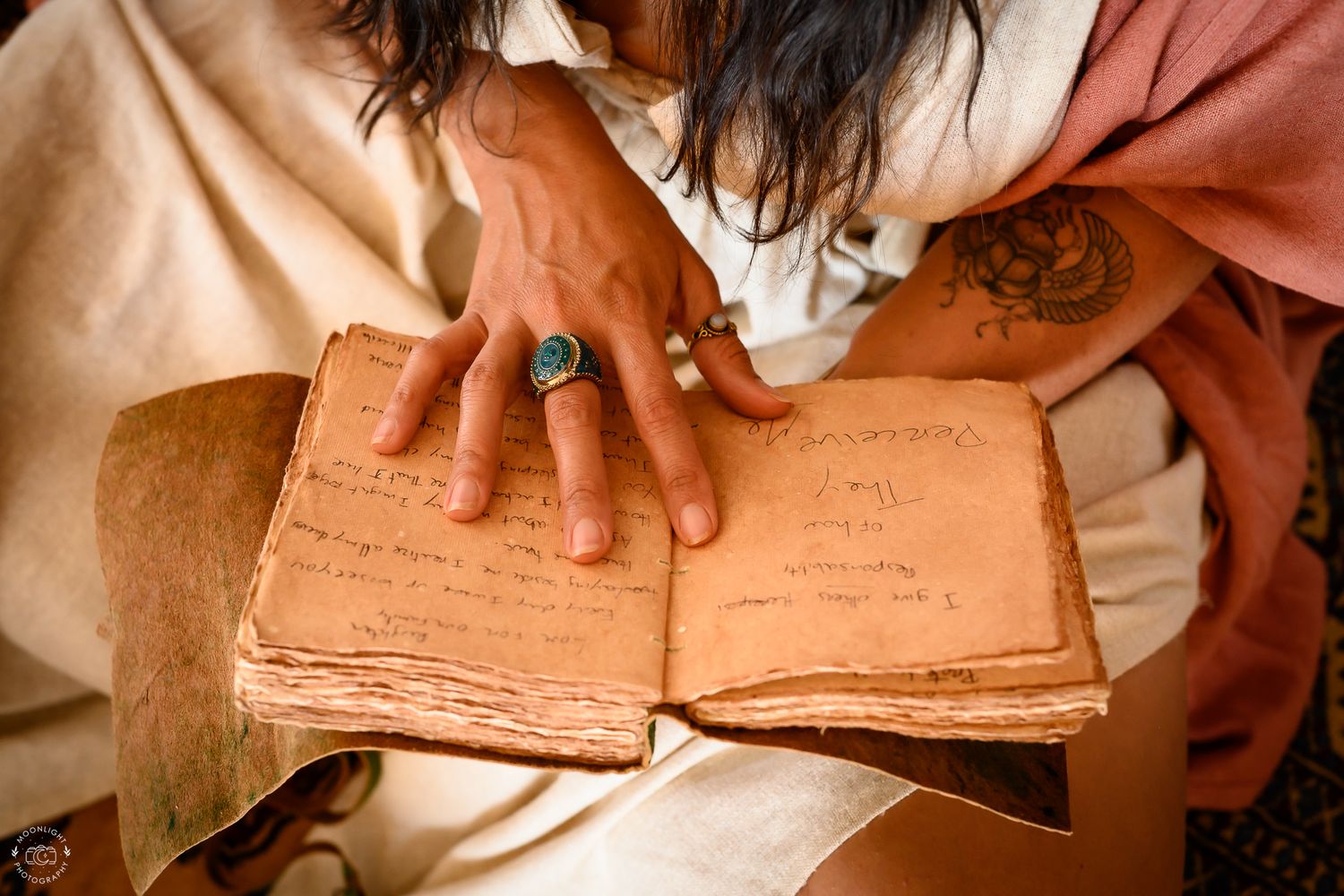 Hands gently turning pages of an aged vintage book in warm sepia lighting.Branding photography Las Vegas