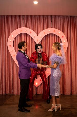 Bride and groom holding hands in front of Elvis at Sure thing Chapel Las Vegas