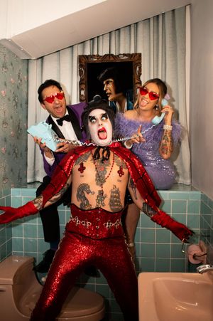 Bride and Groom wrapping phone cord around Elvis at Sure Thing chapel bathroom Las Vegas