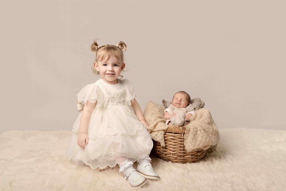 A series of connected photos showing a baby in a white dress sitting and playing with a wicker basket on a beige backdrop.