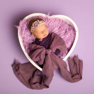 A brown cloth being twisted and wrinkled against a soft purple background in a progressive sequence.