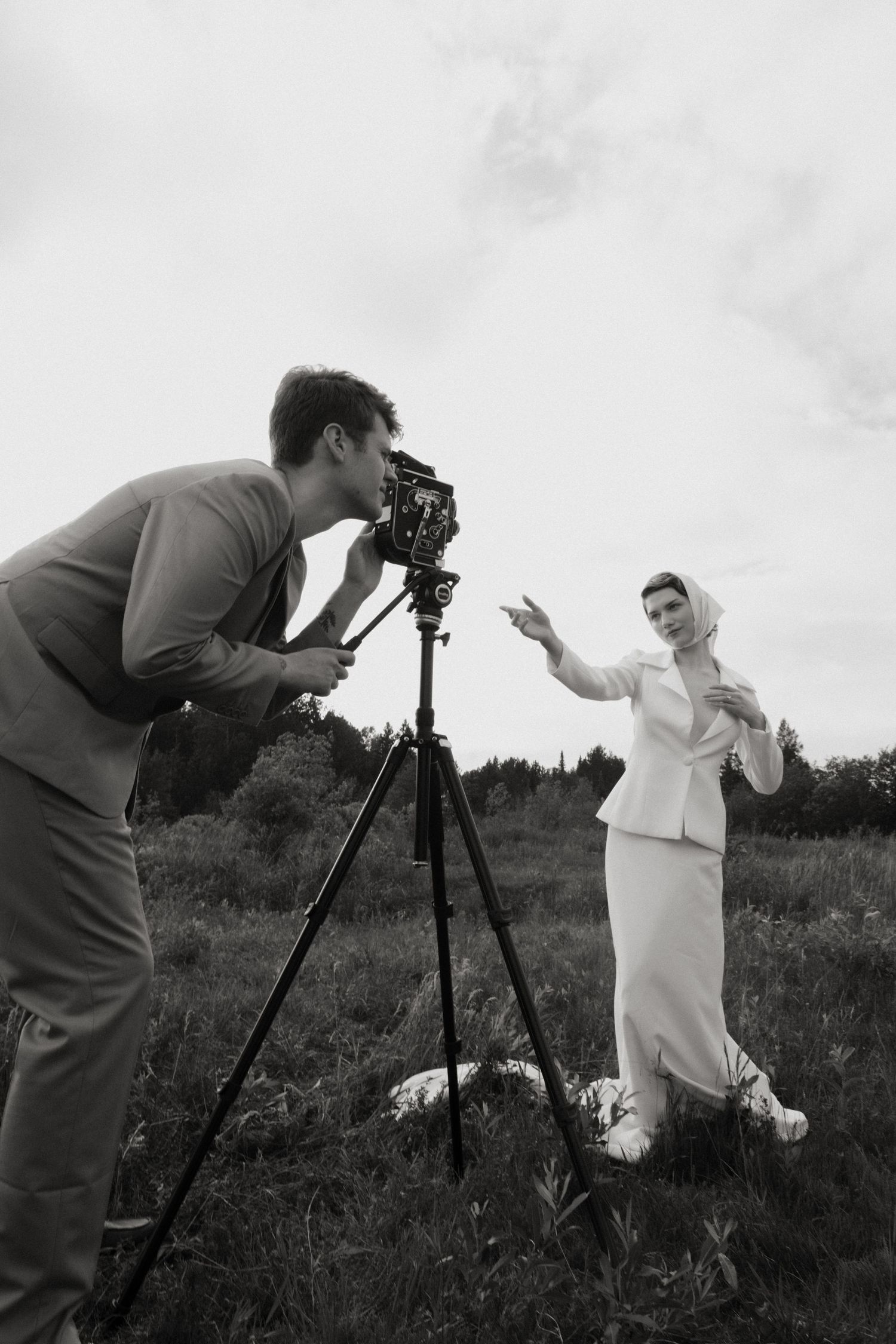 Black and white image of a couple in a rowboat on a serene lake during their wedding.