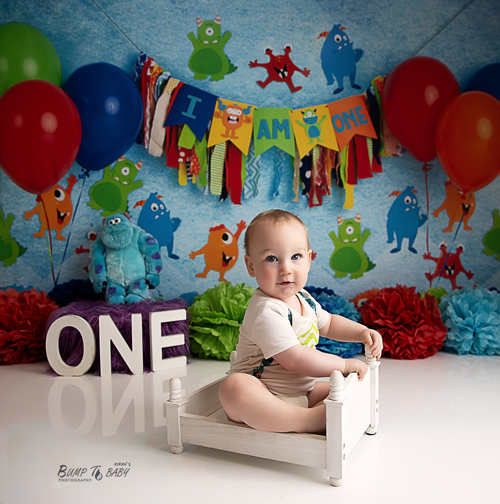 Baby boy laughing during a fun first birthday cake smash session at Bump to Baby Photography, Melbourne East.