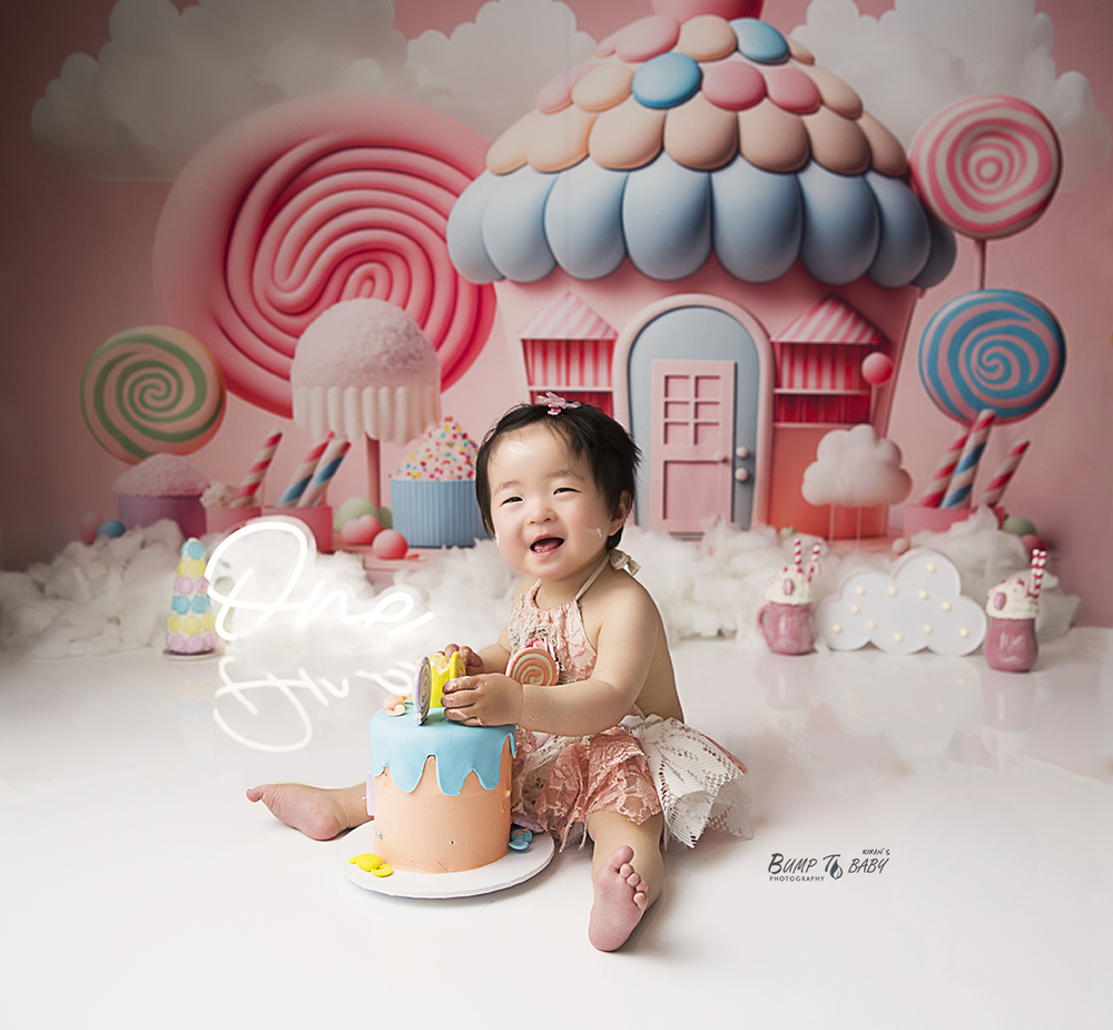 Candy theme first birthday cake smash photoshoot in Croydon Melbourne featuring baby celebrating with colourful sweets, balloons, cake and p