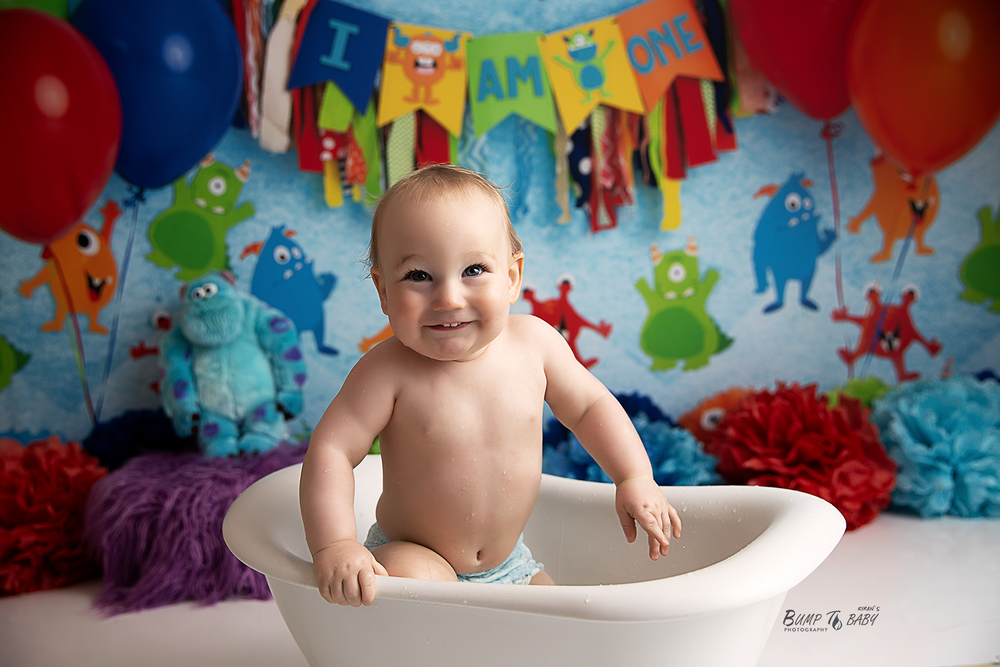 First birthday cake smash photography featuring a happy baby surrounded by balloons and birthday decorations in Croydon, Melbourne.
