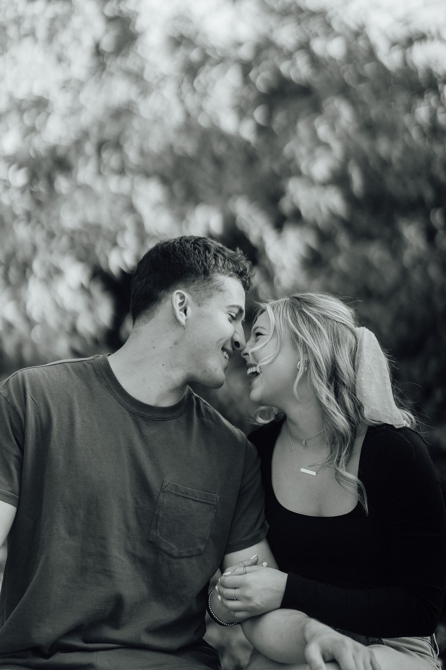 A black and white intimate portrait capturing a tender moment between two people.