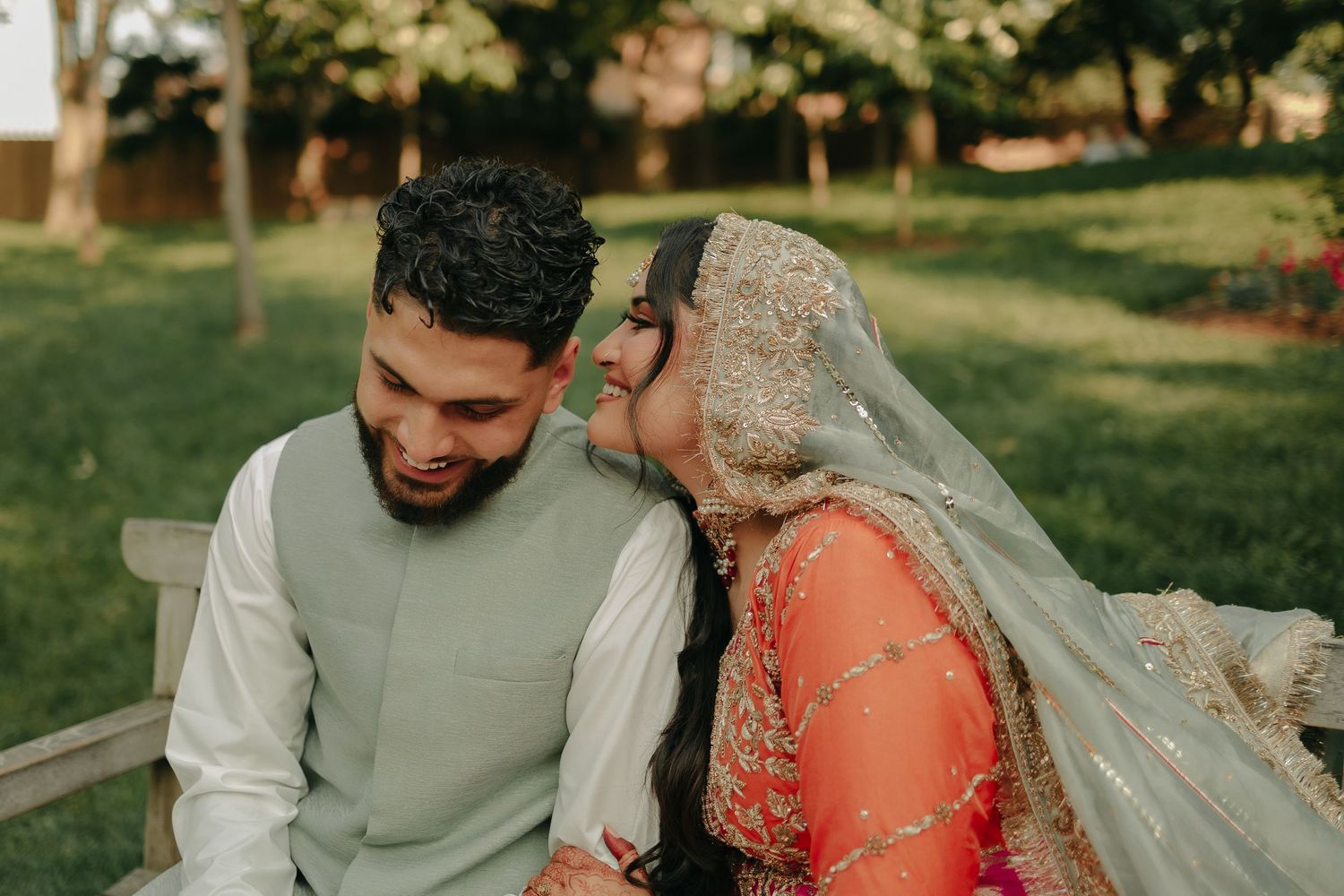 Intimate moment between couple in traditional South Asian wedding attire.