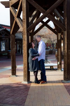 A romantic proposal sequence captured under a wooden gazebo structure.