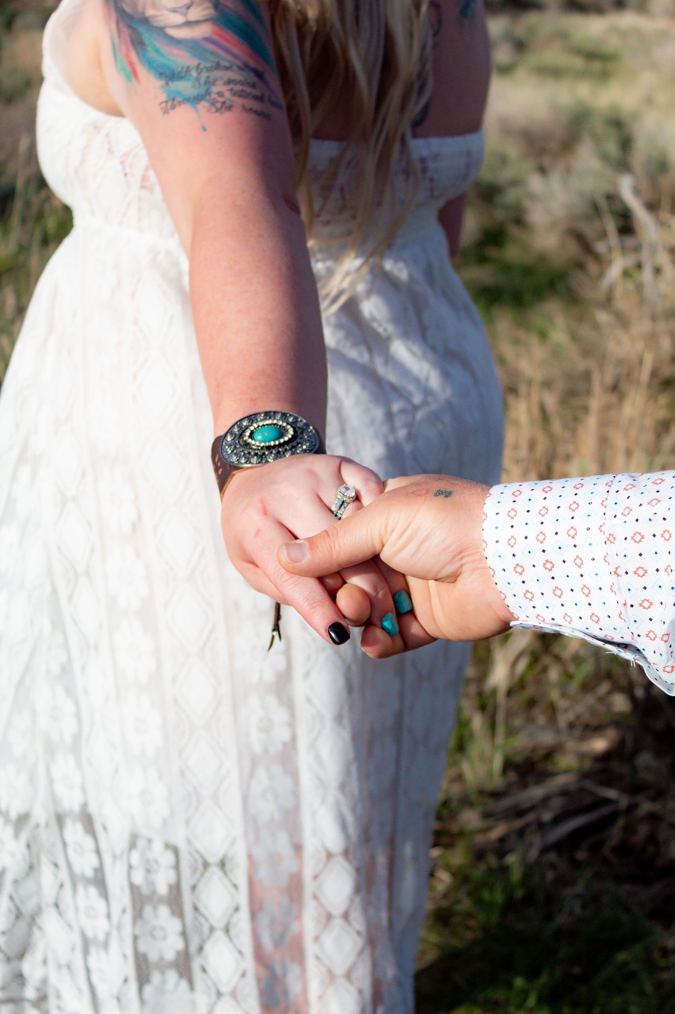 Close-up of hands holding during outdoor wedding ceremony.