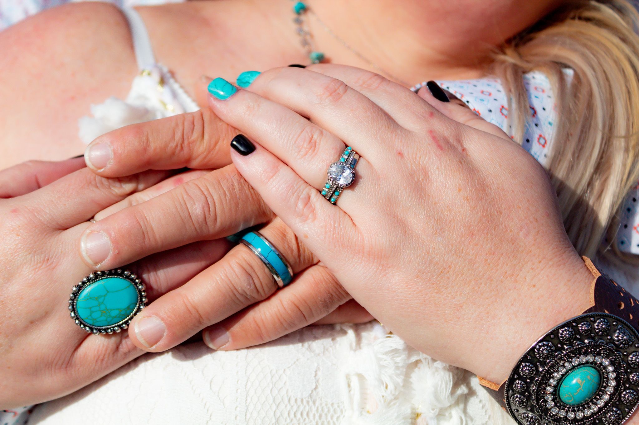 Wedding detail shot showing hands with turquoise jewelry and rings.