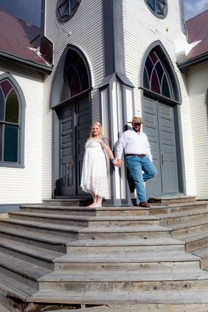 Series showing a couple descending wooden steps of a white church with arched windows.