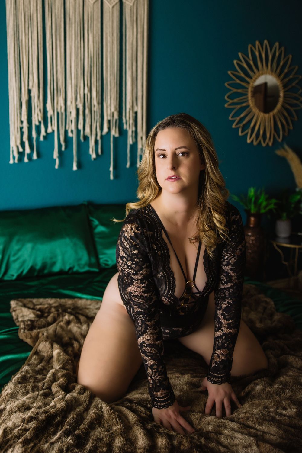 woman in black in front of teal wall