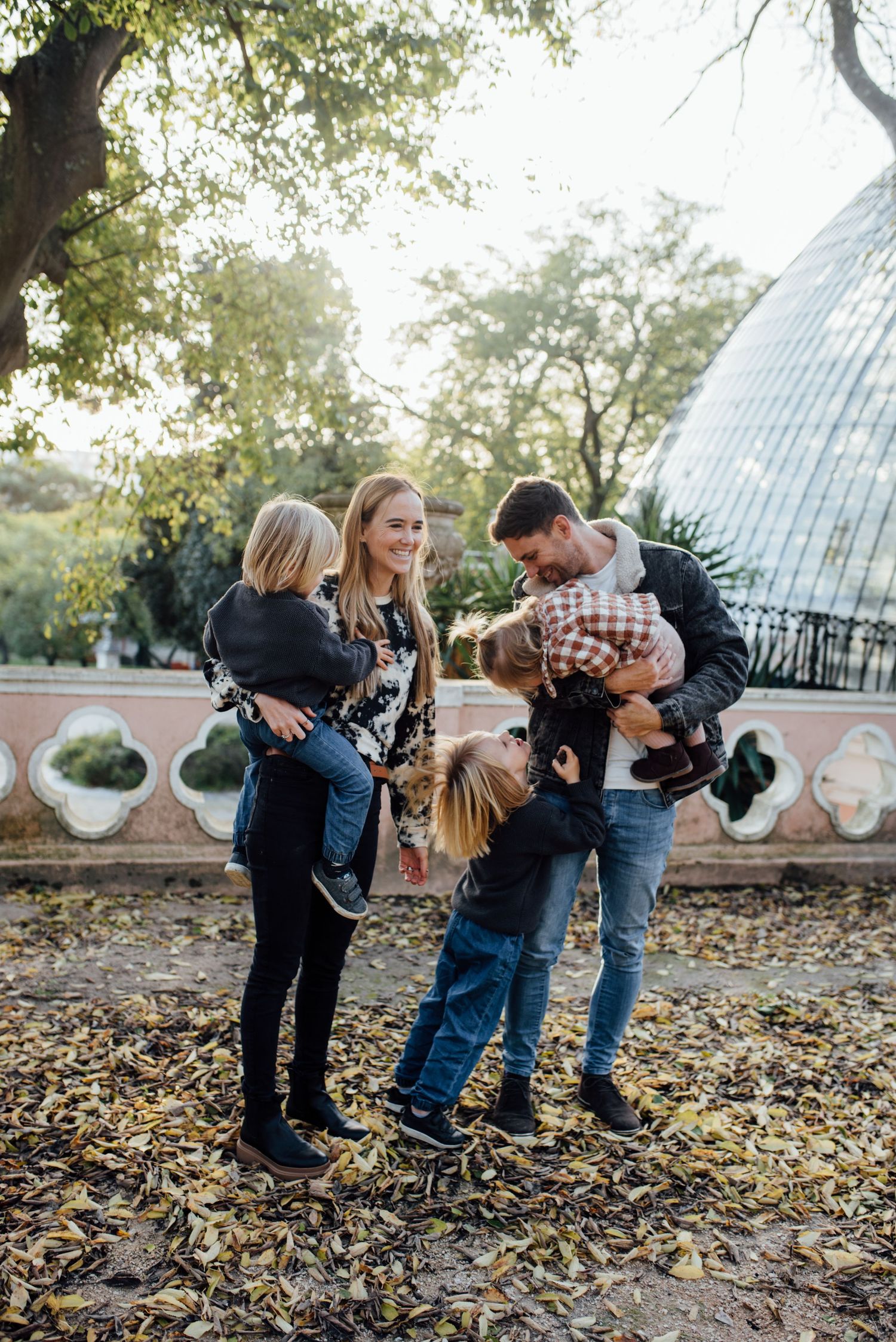 A young family playing in the park at golden hour during Lisbon family photoshoot-