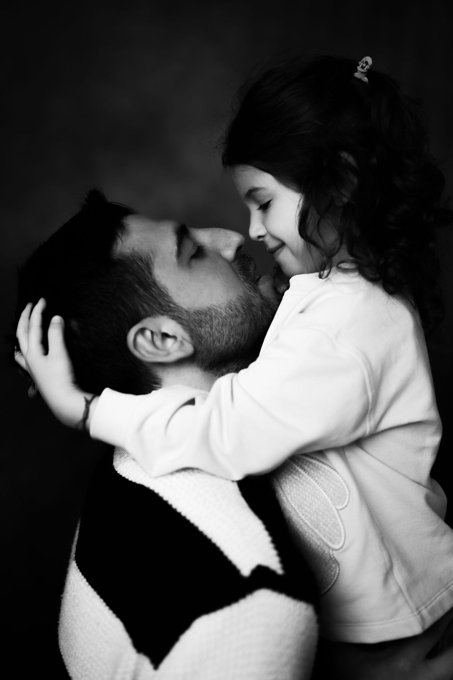 Papà e figlia che si guardano durante un ritratto fotografico in studio dedicato alla Festa del Papà
