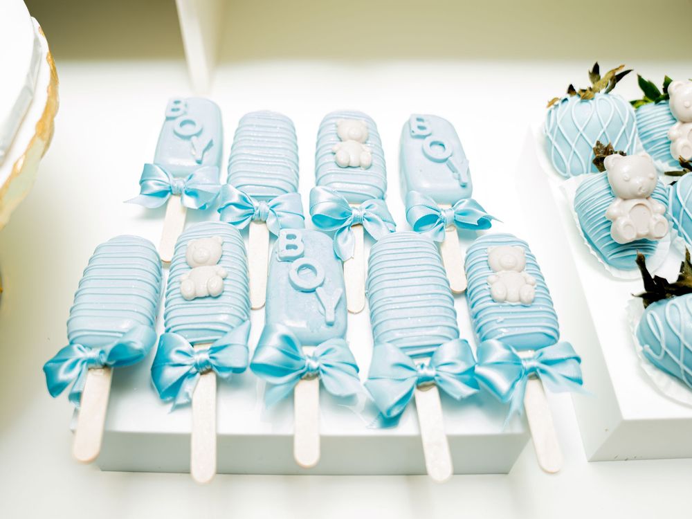 A row of light blue gift boxes with white ribbons arranged in a line on a white surface.