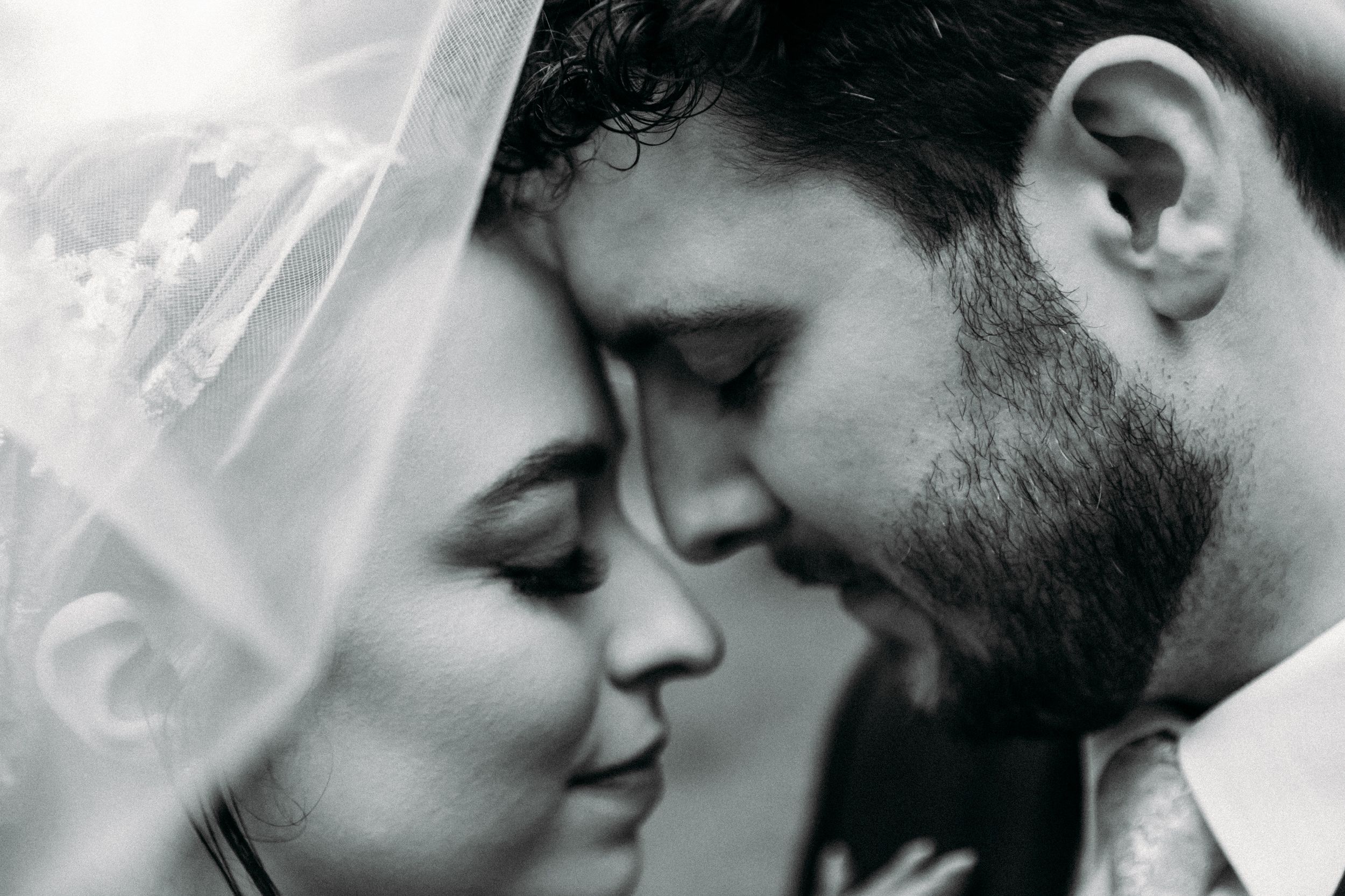 A romantic black and white photo collage showing intimate close-up moments between a couple.