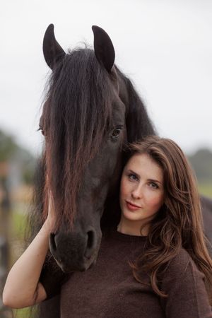 Vrouw houdt de hals van haar paard vast