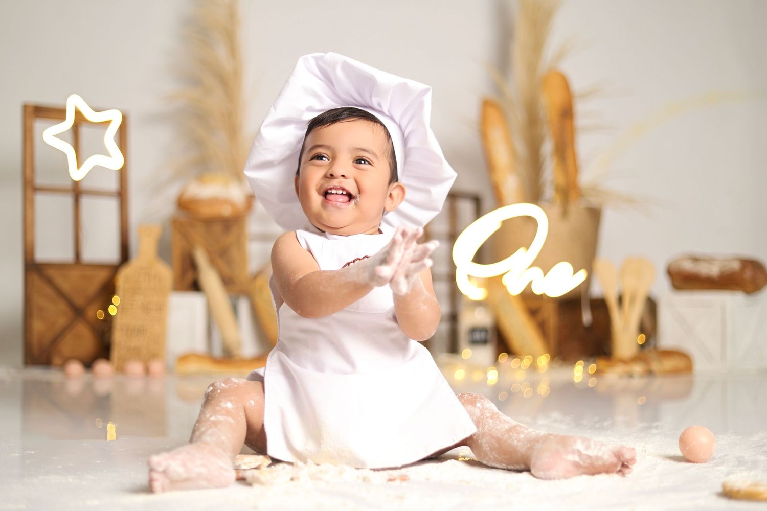Baby photoshoot with chef theme featuring white hat and rustic kitchen backdrop.