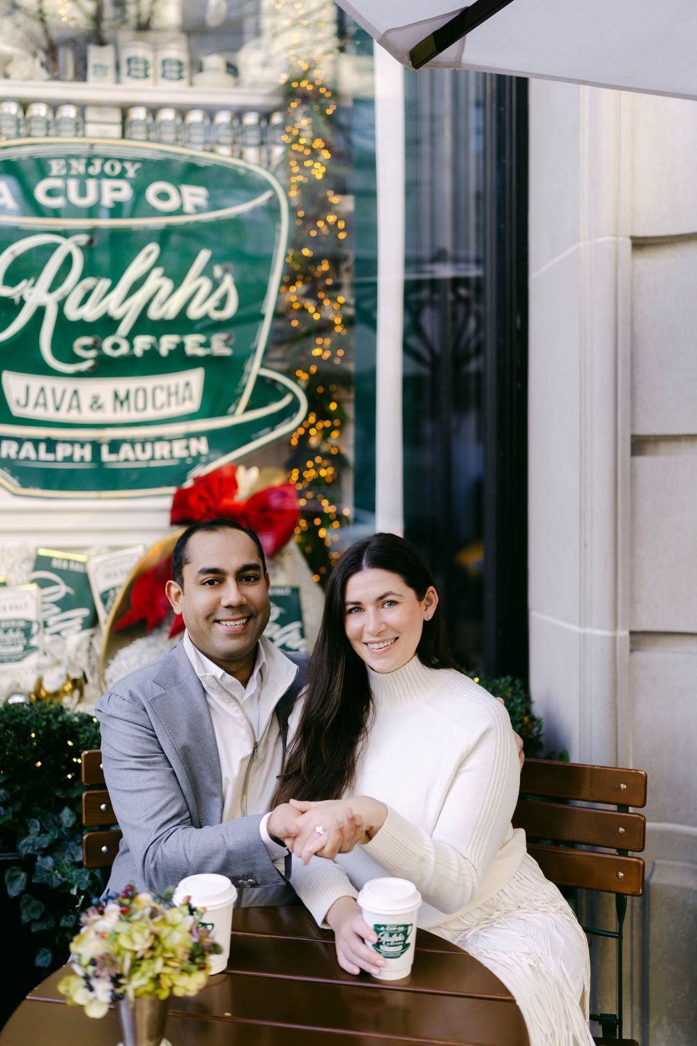 A couple shares romantic moments at a vintage-style coffee shop called Ralph's, decorated with holiday lights and greenery.