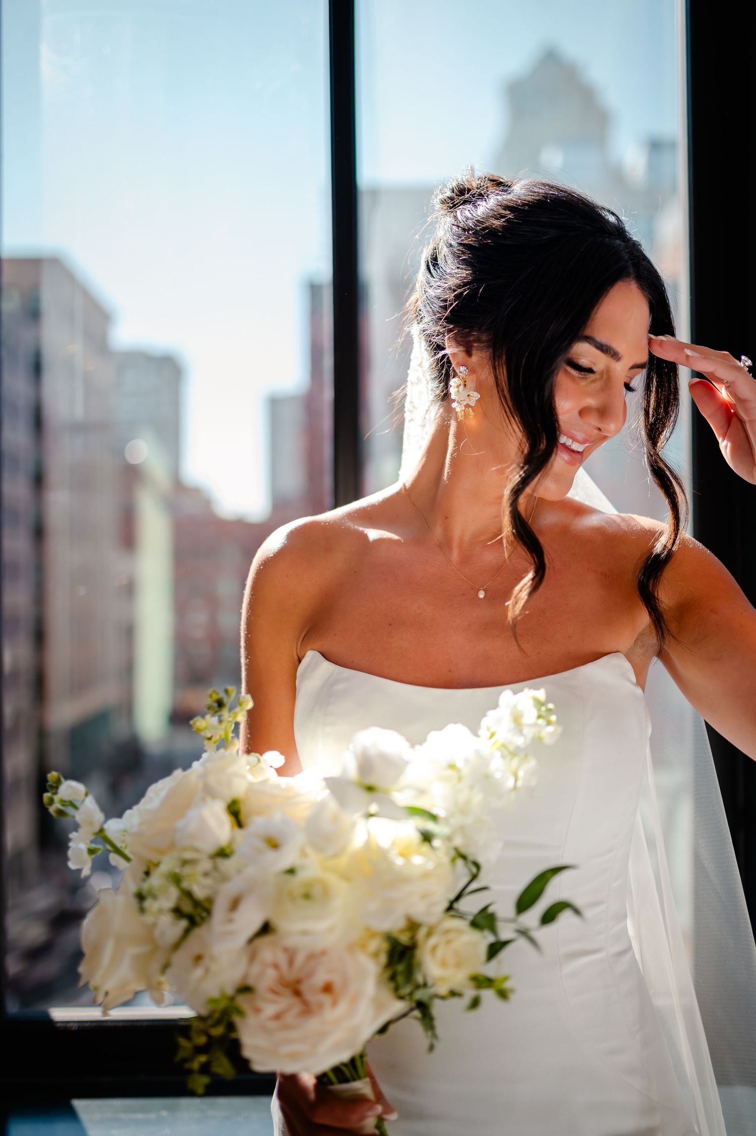A sequence of wedding photos showing a bride in a strapless white gown with delicate floral bouquet by a window.