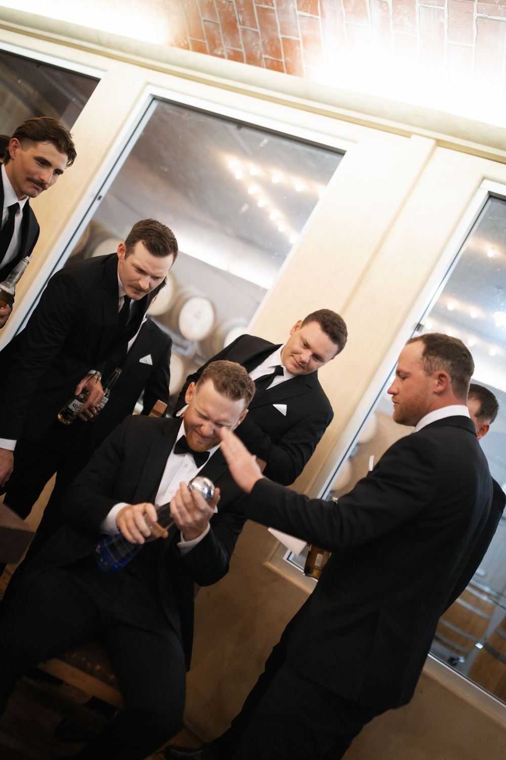 Groomsmen in black suits and ties getting ready before the wedding ceremony.