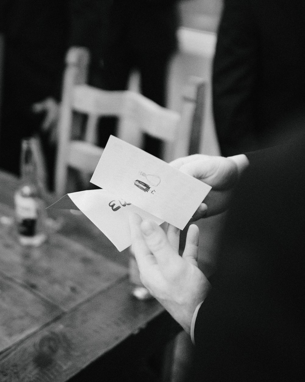 Black and white photograph showing hands holding papers in a sequence of four similar shots.