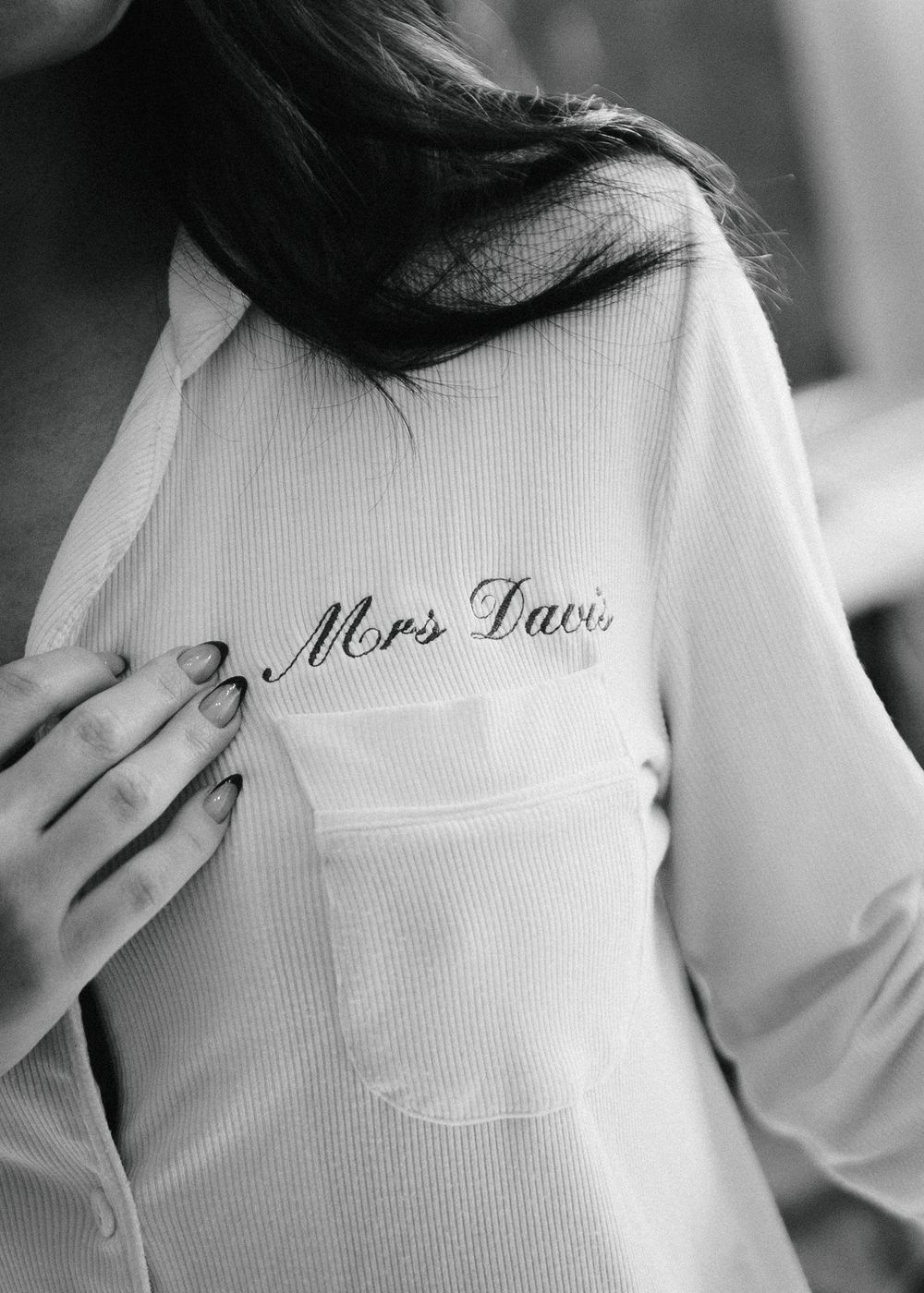 A white thermal waffle knit fabric shown in close-up detail with embroidered red text visible.
