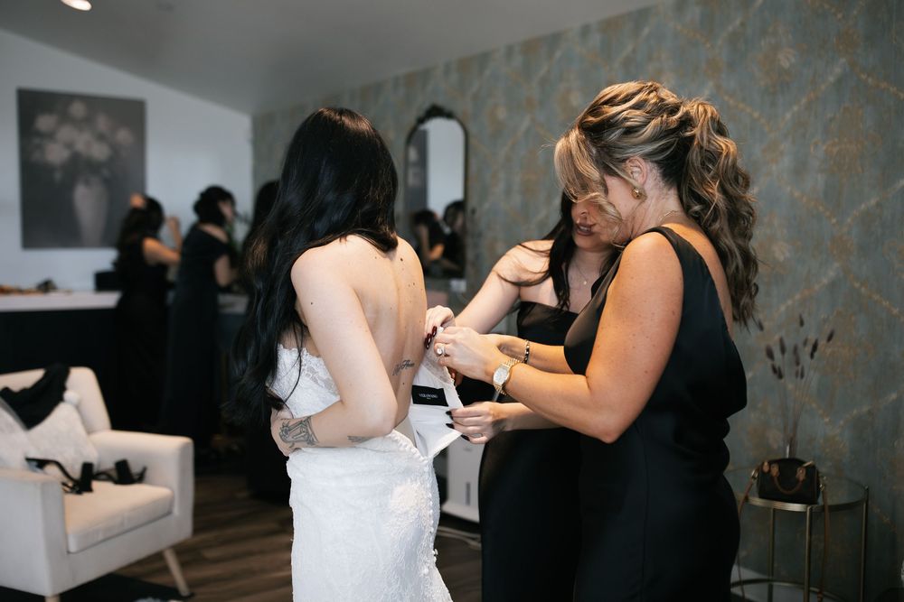 A couple shares a dance moment in a dimly lit indoor venue with textured stone walls.