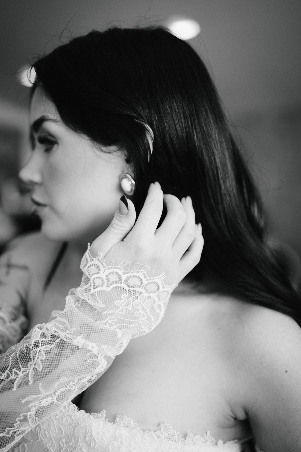 Delicate white lace details on dark fabric shown in black and white photography.