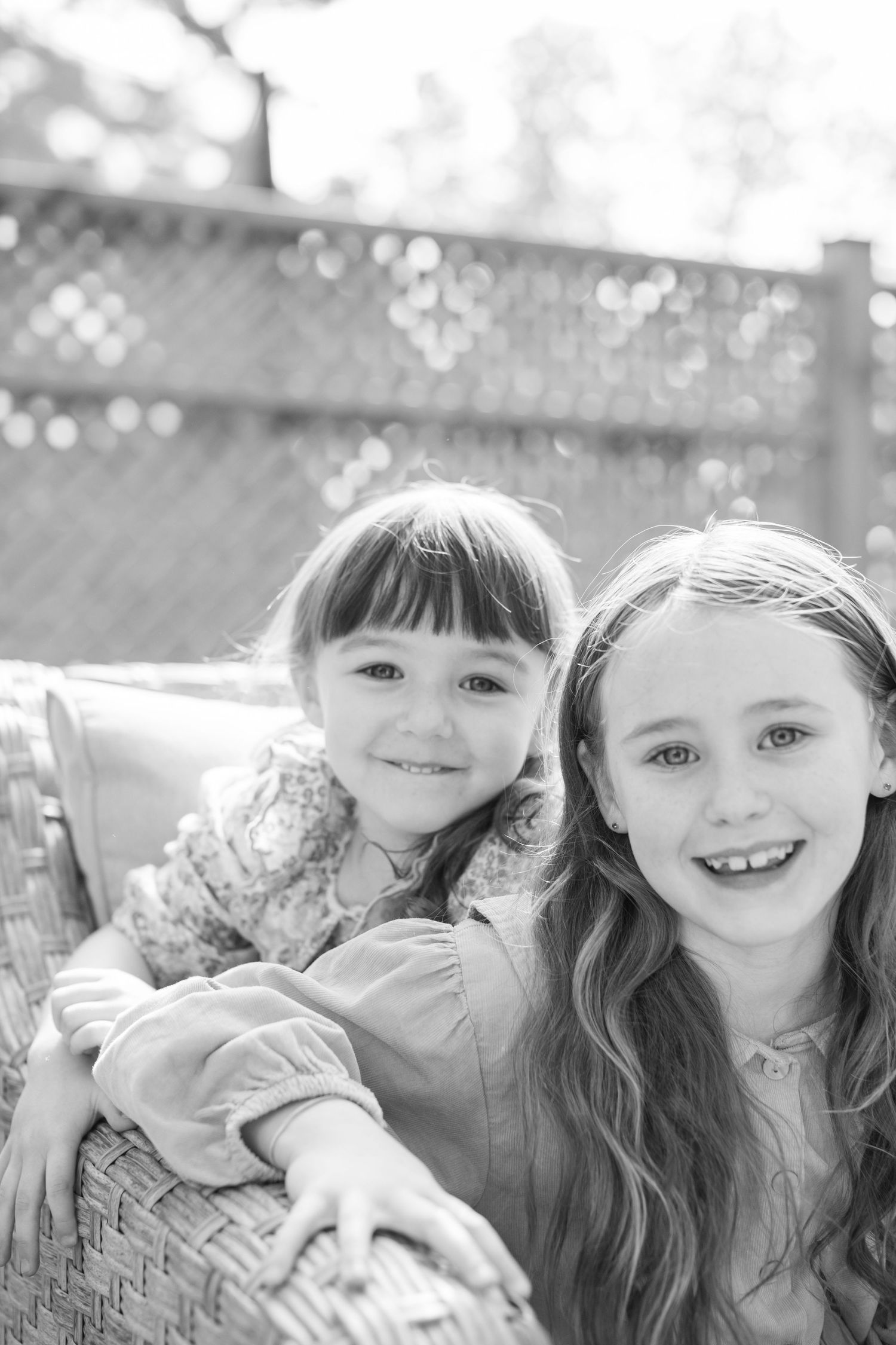 Black and white photo showing children's smiling faces in a row creating a playful collage effect.
