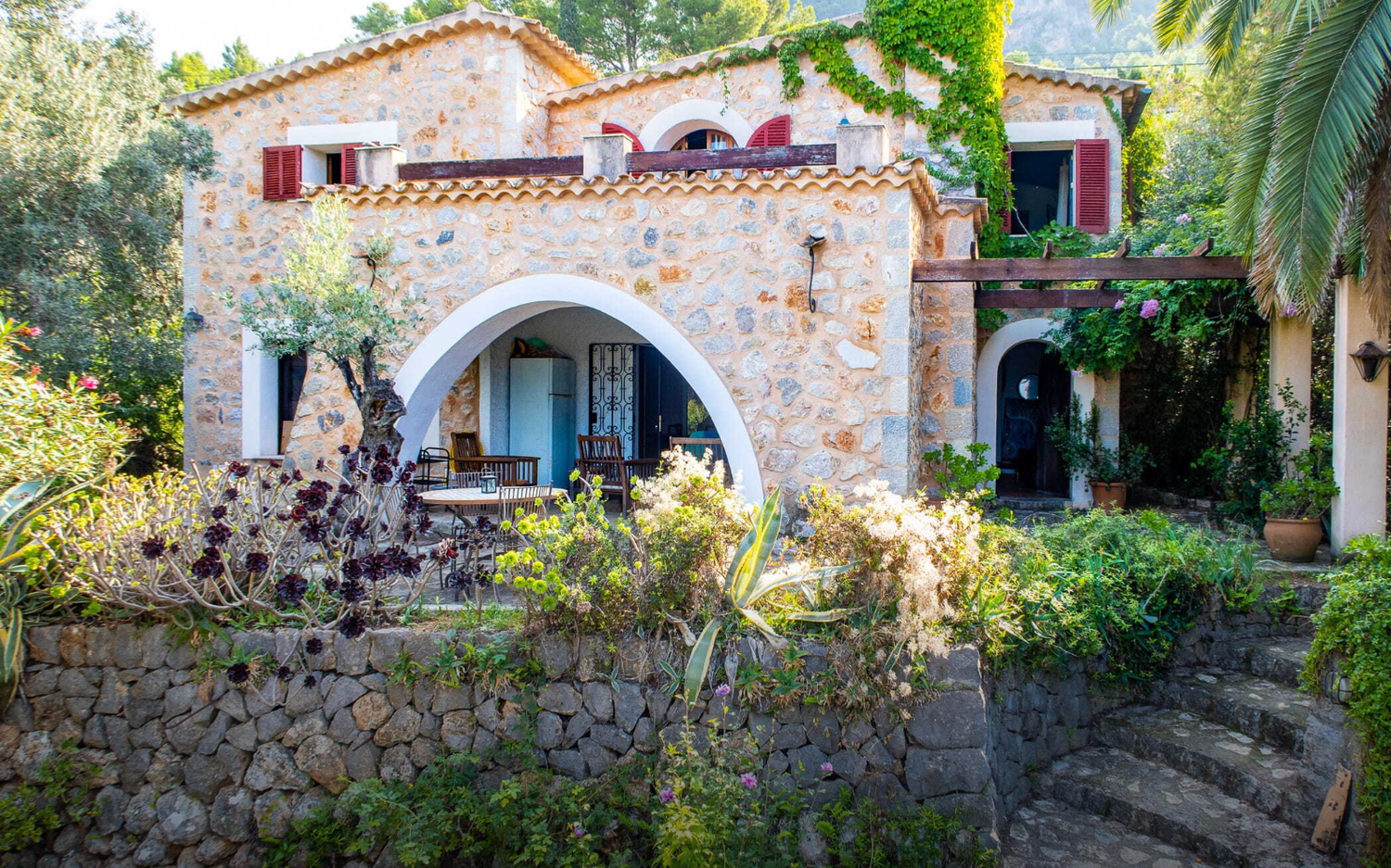 Stunning coastal villa development overlooking Mediterranean Sea during golden sunset with mountains in background.