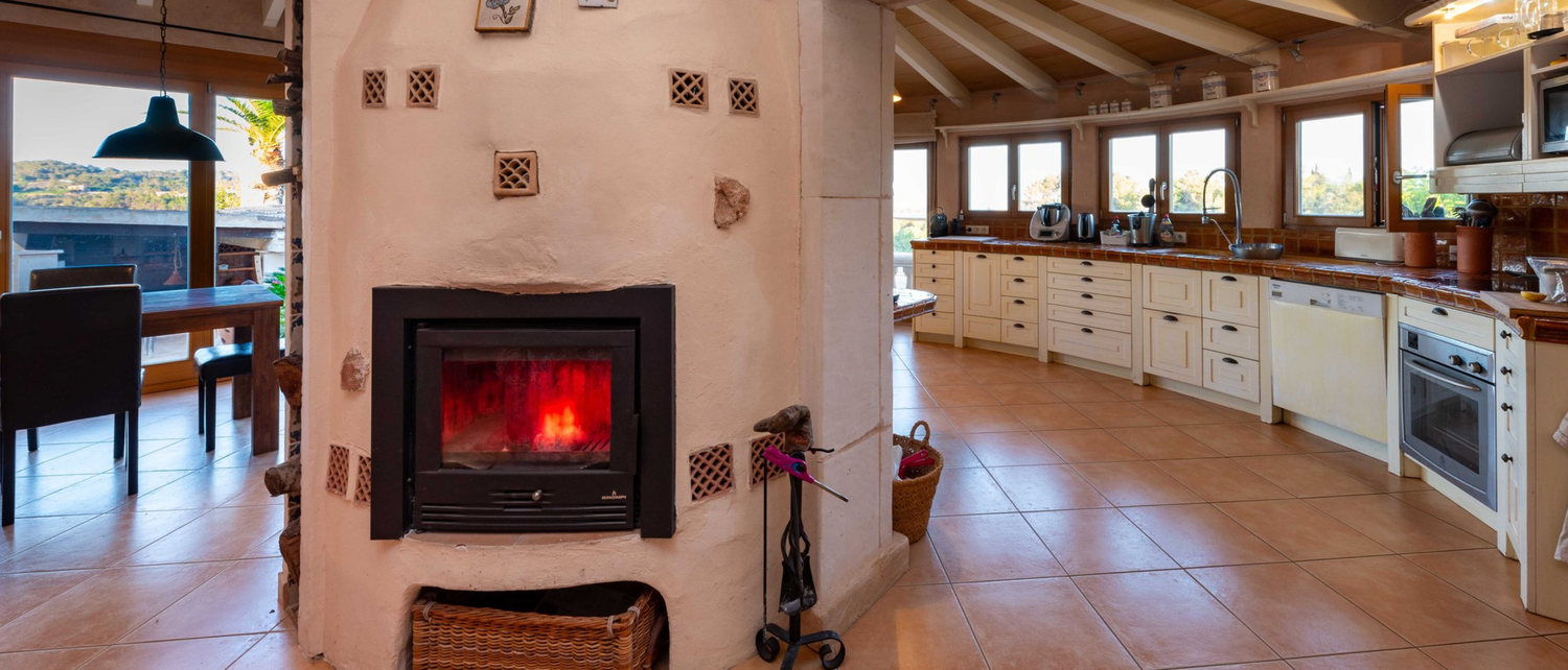 Stone villa with rustic charm features multiple arched windows and doors in a Mediterranean countryside setting.