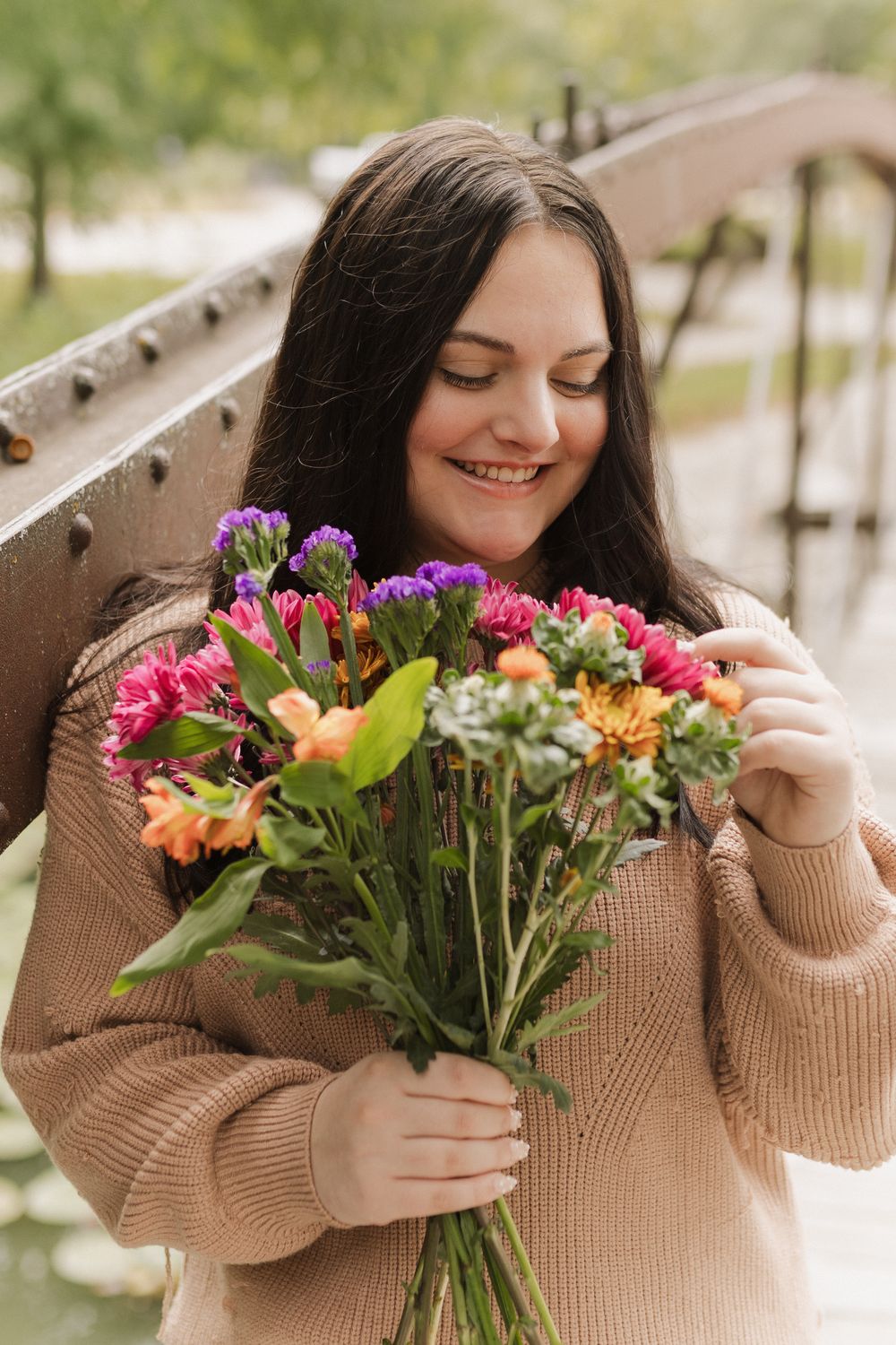 A series of photos showing someone in a beige sweater holding and smelling a colorful bouquet of fresh flowers.