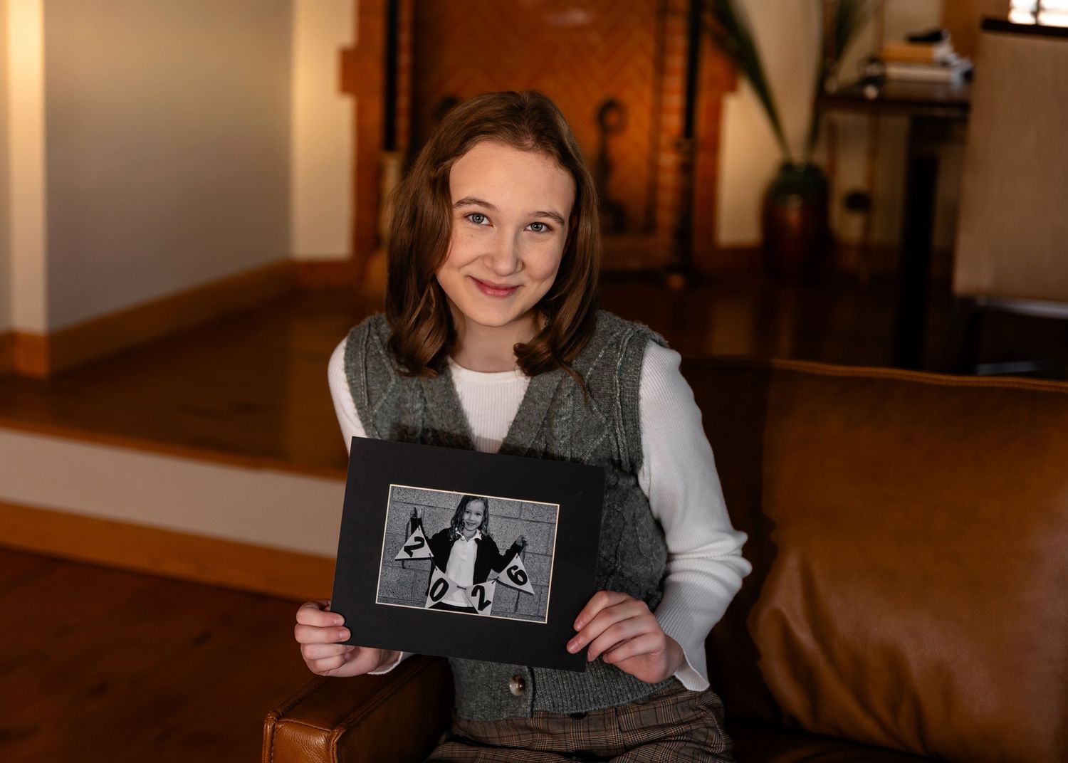 A high school graduate holding her Kindergarten photo in Omaha, NE